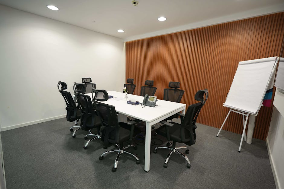 Spacious meeting room featuring ergonomic chairs, a large table, and a flip chart.