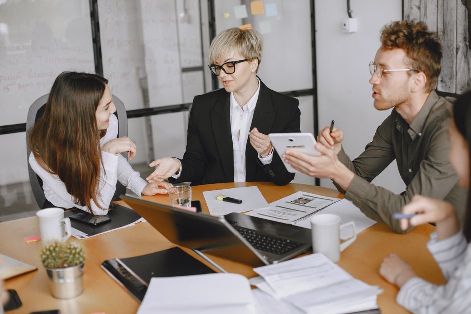 Grupo de profesionales de negocios participando en una reunión para discutir estrategias y cooperación.