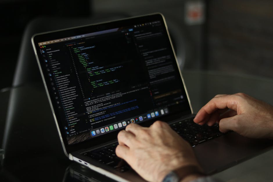 Close-up of hands coding on a laptop, focusing on programming productivity.