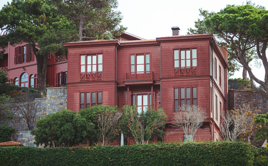 A picturesque red house surrounded by greenery in an urban setting in Istanbul, Turkey.