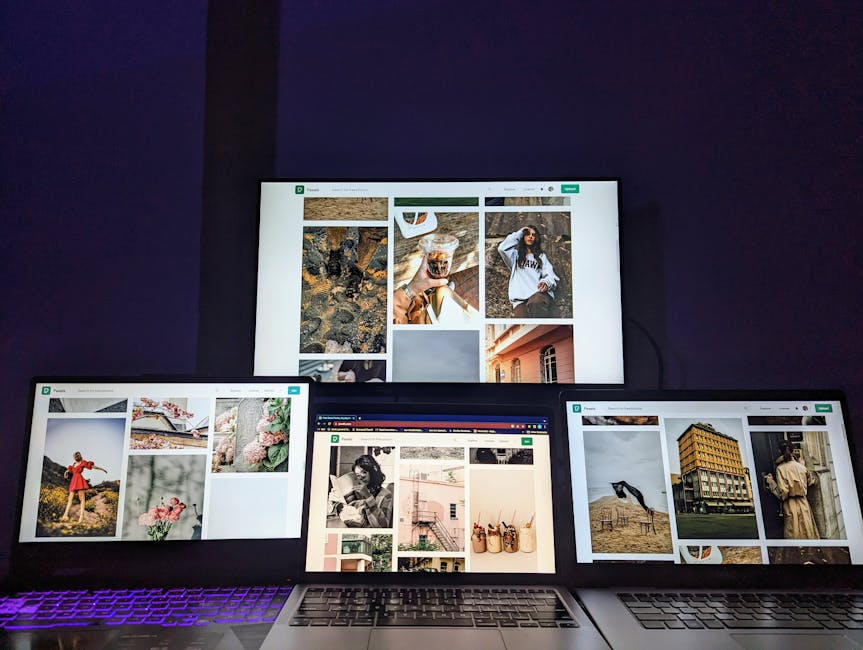A high-tech workspace featuring three laptops and a monitor with various images displayed, highlighting technology and digital art.