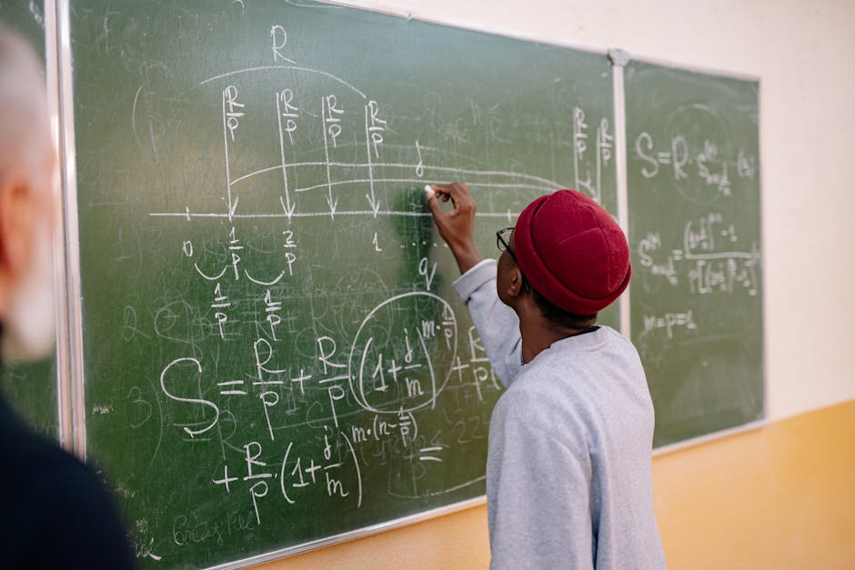 A young student writes mathematical equations on a green blackboard with precision and focus.